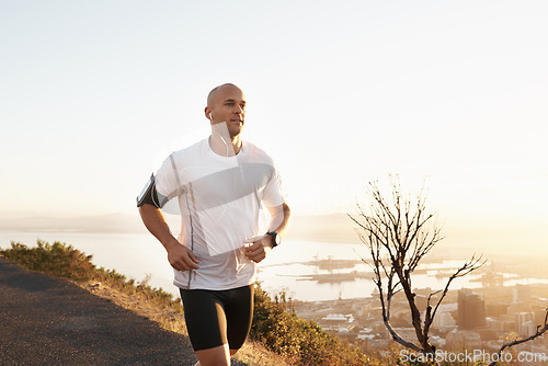 Image of Athlete, man and running in road with music for sport, exercise and fitness for competition or marathon in nature. Runner, person and workout with wellness, seaside and earphones for cardio in Mexico