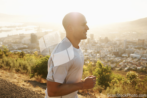 Image of Fitness, running and man in mountain at sunset or health, wellness and strong body development. Workout, exercise and happy runner on path in nature for marathon training, performance and challenge.