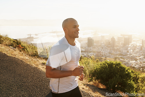 Image of Fitness, hill and man on road running for health, wellness and strong body development. Workout, exercise and runner on path in nature for marathon training, performance and morning challenge in city