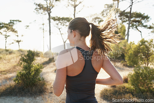 Image of Fitness, running and woman on path in forest for health, wellness and strong body development. Workout, exercise and girl runner on road in nature for marathon training, performance and challenge.