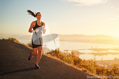 Image of Fitness, running and woman on cliff at sunset for health, wellness and strong body development. Workout, exercise and girl runner on path in nature for marathon training, performance and challenge.