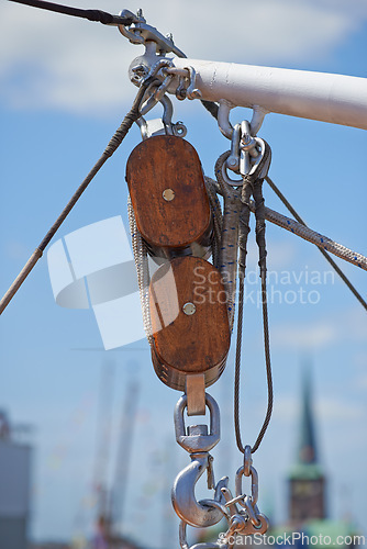 Image of Closeup, pulley and hook with rope on ship, dock or harbor with transport and navigation for sailing. Yacht, cruise with journey or travel, cable and chain for nautical vessel, equipment and rigging