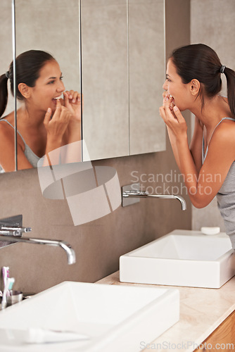 Image of Mirror, bathroom and woman with floss for cleaning, oral hygiene and dental care in home. Morning routine, healthcare and person for whitening, wellness and grooming for gum disease and fresh breath