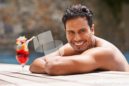 Image of Man, relax and portrait at swimming pool with cocktail at hotel, resort and travel on luxury vacation. Summer, holiday and glass of alcohol to drink with happiness on deck at poolside in Mexico