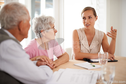 Image of Senior, couple or financial advisor with discussion for insurance, retirement planning or contract documents by table. Elderly, people or consultant with paperwork for title deed or pension agreement