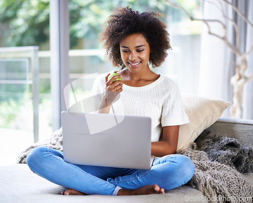 Image of Apple, smile and woman on sofa with laptop for social media, lifestyle blog and food website at home in Houston. Happy female person, technology and fruit for nutrition, healthy diet and clean eating