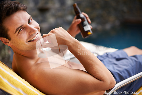 Image of Portrait, man and relax by swimming pool with beer to drink or chill on summer vacation, luxury and resort or villa. Male person, bottle and alcohol for refreshments on tropical holiday in Maldives.