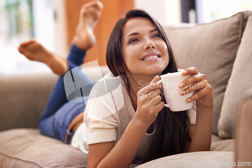 Image of Woman, coffee and thinking on sofa with smile for relax weekend contemplation for holiday, carefree or peace. Female person, beverage and thoughts on home couch in Mexico or calm, resting or vacation