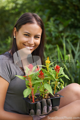 Image of Happy woman, portrait with flowers and garden in backyard, nature and sustainability for environment. Landscaping, gardener with plant in soil or fertilizer for growth, eco and botanical outdoor