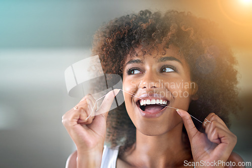 Image of African woman, dental floss and happy for cleaning for oral wellness, health or benefits for mouth in bathroom. Girl, person and teeth whitening with string, lens flare or change for results in house