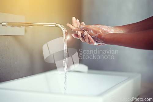 Image of Hands, water and soap for cleaning with person in bathroom, hygiene and wellness for protection from germs. Bacteria, virus and disinfection at sink with foam, skincare and cosmetics in routine