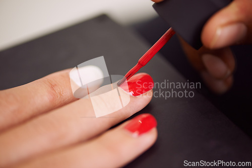 Image of Woman, hands and manicure with red nail polish for beauty, cosmetics or finger treatment at salon. Closeup of female person or stylist applying glow, shine or glamour on cuticles for makeup or art