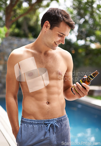 Image of Man, look and happy by swimming pool with beer to relax or chill on summer vacation, luxury and resort or villa. Male person, bottle and alcohol for refreshments on tropical holiday in Maldives.