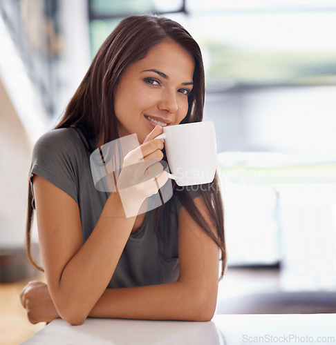 Image of Portrait, coffee and happy with woman in kitchen of home to relax in morning or on weekend time off. Smile, relax and mug with face of young person drinking tea in apartment for peace or wellness