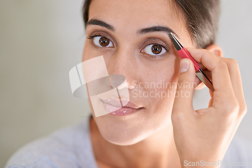 Image of Portrait, cosmetics and tweezer with eyebrows of woman in mirror of home bathroom for grooming or hygiene. Beauty, cleaning or wellness with face of young person in apartment for morning hair removal