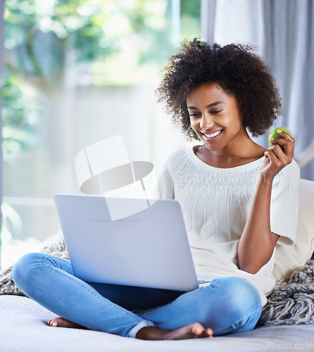Image of Apple, fresh produce and woman on sofa with laptop for social media, lifestyle blog and food website at home. Happy female person, technology and fruit for nutrition, healthy diet and clean eating