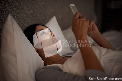 Image of Woman, scroll and phone for social media, bed and relaxation under blankets in pajamas to sleep. Female person, browse and tech for peace, night and online for conversation, chat and meme leisure