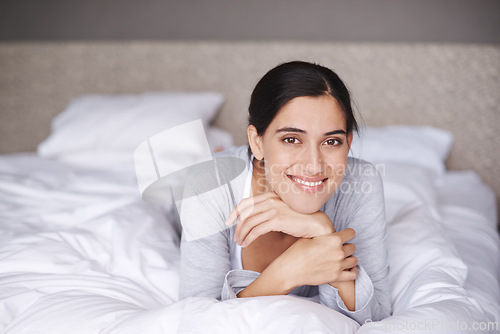Image of Portrait, bed and duvet of happy woman, bedroom and home for comfort and sleep. Smile, relax and bedding in room for rest for fatigue, wellness and refresh or joy on weekend chill in pyjamas