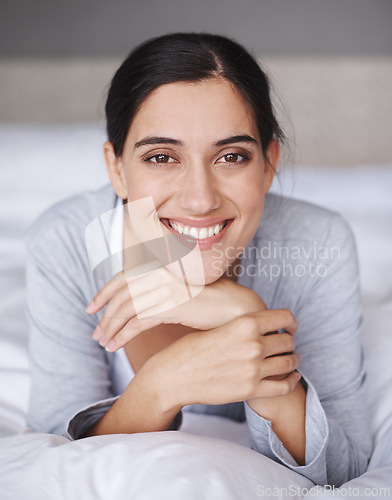 Image of Portrait, bed and smile of relax woman, bedroom and home for comfort and sleep. Duvet, happy and bedding with rest or face from fatigue, wellness and refresh or joy on weekend chill in pyjamas