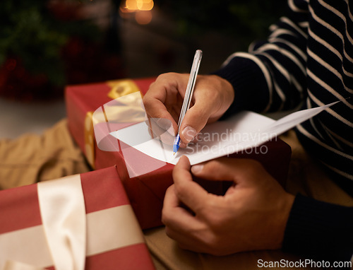 Image of Pen, hands and man with card and gift for Christmas event or party at home for family. Celebration, paper and closeup of male person writing letter with present boxes for xmas festive holiday.