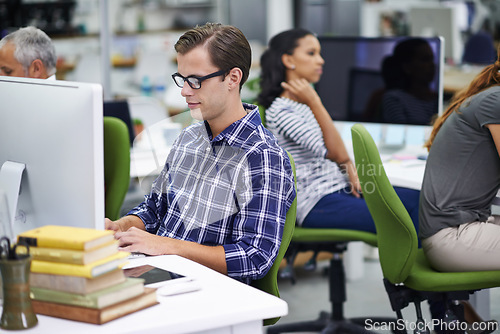 Image of Man, working and desk with coworkers on computer in office, digital design for online research for business website. Colleague, career and employees for creative company, typing or browse on internet