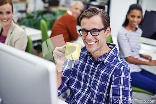 Image of Man, smile and desk with coffee on computer in office, digital design for online research for business website. Colleague, career and employees for creative company, typing or browse on internet