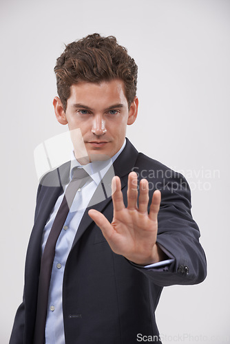 Image of Businessman, hand and stop with sign for rejection, no or decline on a gray studio background. Young man, model or employee showing palm, gesture or symbol for wait, warning or refusal on mockup