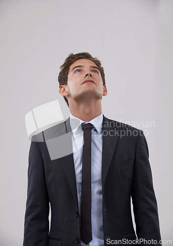 Image of Businessman, thinking and looking up with dream on mockup for idea on a gray studio background. Isolated young man, model or employee in business suit, wonder or thought for career plan or mindset