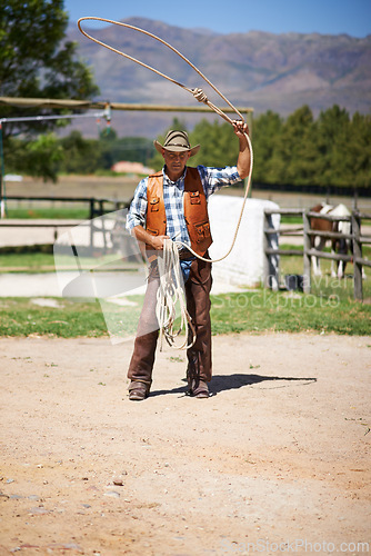 Image of Cowboy, ranch and lasso in boots, sun and straps for wrangler and Texas farmer at stable. Mature man, wild west and summer in agriculture, hat and male person with rope in farm job and environment