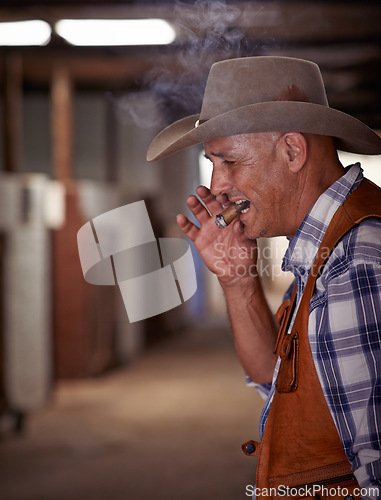 Image of Smoke, cigar and senior cowboy on ranch for farming, agriculture and care for rodeo animals. Western, countryside and mature farmer, man and rancher with cigarette, tobacco and smoking in Texas