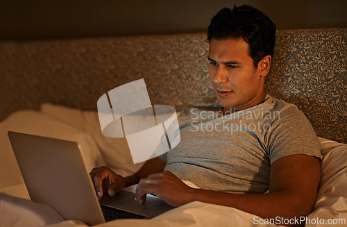 Image of Man, happy and laptop in bedroom at night, online subscription and streaming movie to watch on weekend. Calm person, relax and computer on bed in duvet, wellness and scroll on social media in home