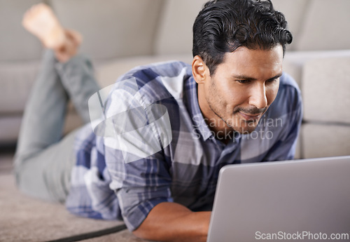 Image of Man, freelancer and internet for laptop on floor of living room, research and scroll or browse on website. Male person, happy and online for information or home for app, remote work and plan on tech