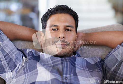 Image of Man, portrait and sofa to relax in home, smile and satisfaction with lying on weekend. Happy male person, lounge and calm or comfortable in apartment, closeup and confident for peace and living room