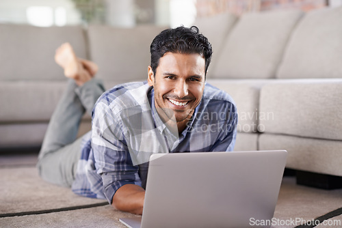 Image of Man, freelancer and portrait for laptop on floor of living room, research and scroll or browse on web. Male person, happy and online for information or home for app, remote work and internet for plan