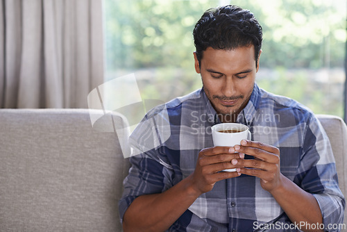 Image of Man, couch and relax with coffee for morning, routine or solitude, comfort and calm for peace. Male person, warm beverage and aroma for satisfaction or happiness with contentment and ease in lounge.