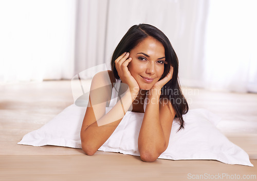 Image of Portrait, smile and comfort on floor with woman in bedroom of home for morning or weekend time off. Relax, wellness and pillow with happy young person lying in apartment for chilling or resting