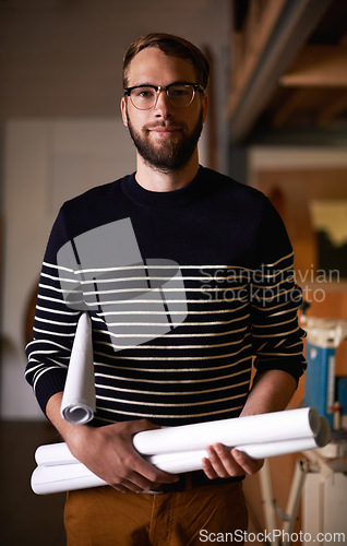 Image of Portrait, architect and man with blueprint, engineering and real estate in a workshop with construction. Face, entrepreneur and employee with documents and maintenance with renovation and startup