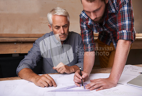 Image of Architects, collaboration and men with blueprint in workshop for building, construction or repairs. Engineering, design and industrial apprentice planning and working on industry project with mentor.