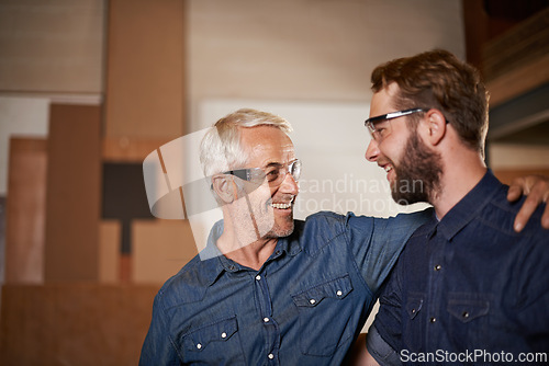 Image of Man, hug and smile with wood, workshop and family business or apprenticeship. Mature father, son and embrace with artisan, carpentry and together for startup and mentor or learning with happiness