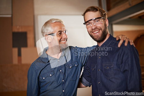 Image of Man, embrace and smile with wood, workshop and family business or apprenticeship. Mature father, son and hug with artisan, carpentry and together for startup and mentor or learning with happiness
