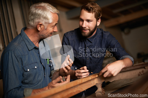 Image of Carpenter, mentor and furniture building in workshop, learning and talking in small business factory. Smile, happy and teaching of apprentice, professional and discussion of technique and skills