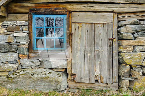 Image of Rustic charm of a weathered wooden cabin with stone foundation a