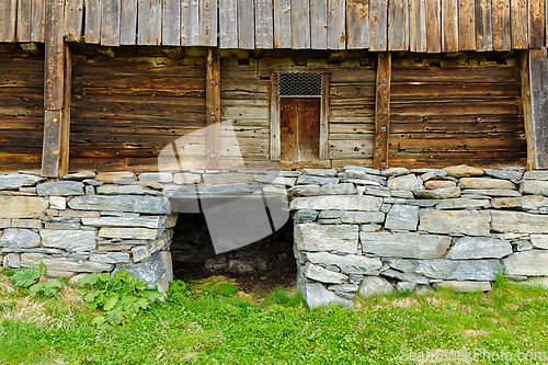 Image of Rustic charm of an ancient stone foundation barn at twilight