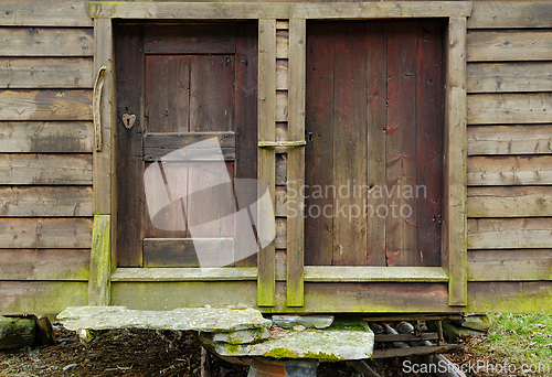 Image of Time-worn wooden doors of a rustic countryside barn on a cloudy 