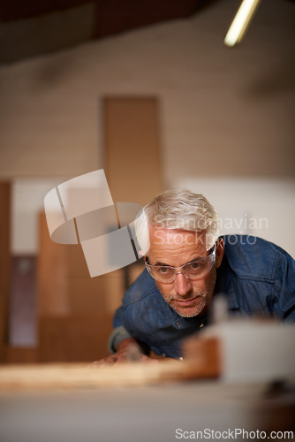 Image of Carpenter, mature man and working with wood in workplace of workshop as construction worker in company. Employee, male person and professional thinking with glasses for safety in garage and shop