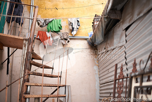 Image of Stairs, outdoor and steel house with rust in zinc material with garbage at informal settlement or neighborhood in Brazil. Home, residential area and community with old or slum building in urban place