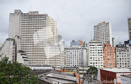 Image of Cityscape, skyline and buildings in urban architecture with development, expansion and clouds in sky. City, metro and skyscraper with road, fog or winter morning on location with road in Sao Paulo