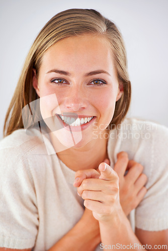 Image of Portrait, pointing and woman in home for motivation, choice or selection in living room. Face, happiness and female person for decision with opportunity, invitation or good mood in apartment