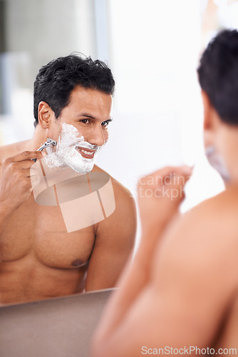 Image of Hair removal, man and shaving foam on face in bathroom mirror for grooming, morning routine and razor. Smile, skincare and male person for wellness, facial treatment or cosmetics with reflection.