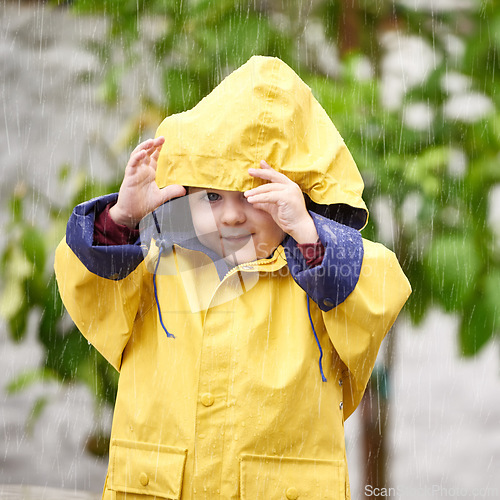 Image of Winter, rain and portrait of boy with jacket for cold, vacation and happiness with enjoyment in Australia. Little kid, face and smile in nature for weekend, adventure or holiday in gloomy weather